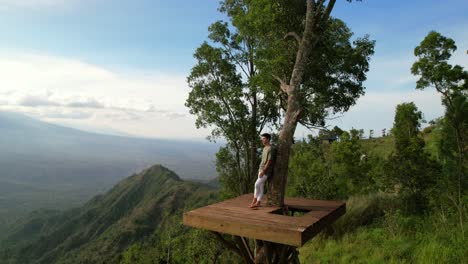 man at popular tourist attraction in bali at lahangan sweet viewpoint, aerial