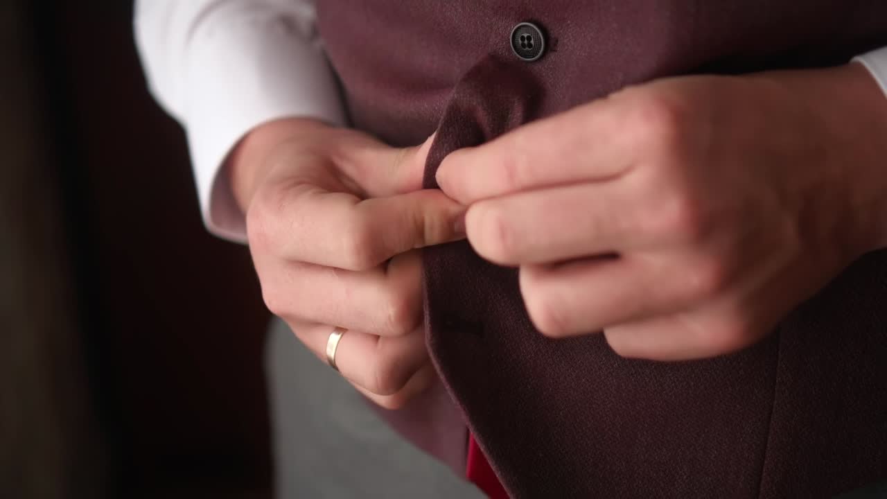 한 남자가 슈트의 버튼을 니다.