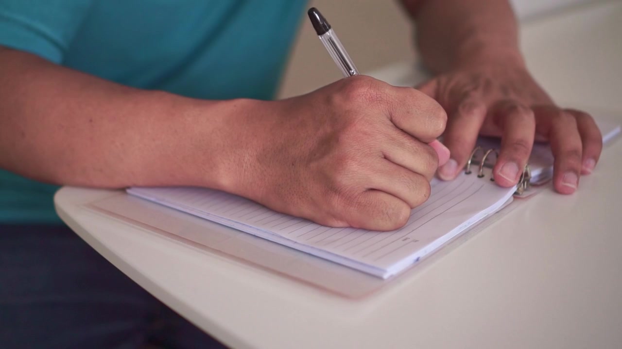 hands writing in a notebook, making a note or journal. A realistic concept of learning and study.