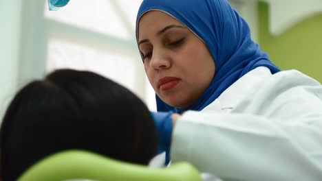female muslim dentist with patient at the dental clinic - close up
