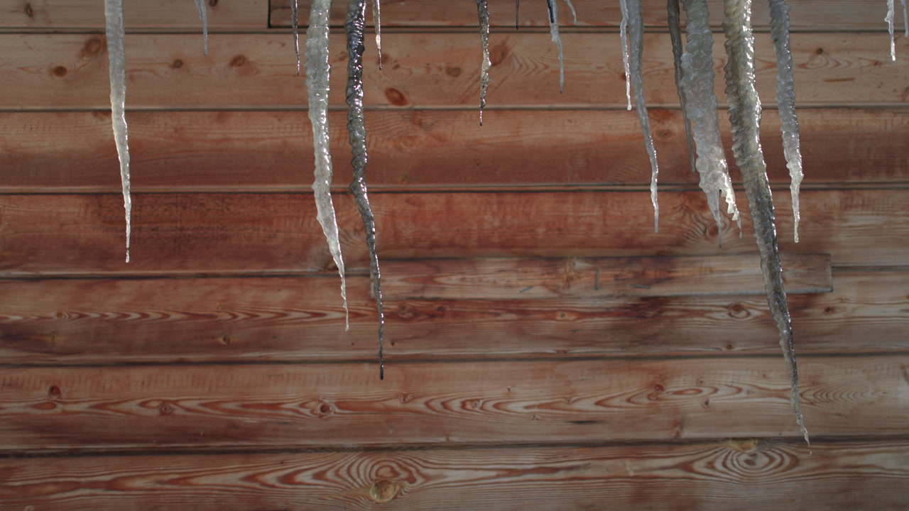 Icicles Dripping Along Wooden Siding With Sunlit Droplets, Translucent Spikes Contrast With Warm Wood Grain, . Media
