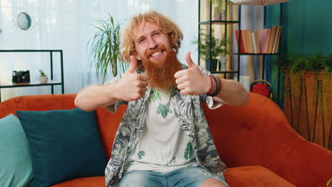 happy caucasian man looking approvingly at camera showing thumbs up like positive sign good news