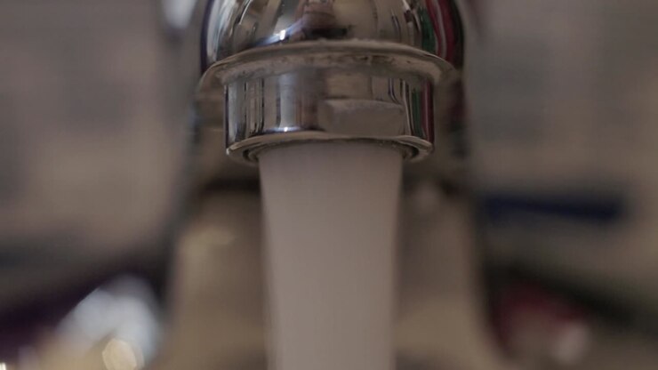 Primo piano di acqua che scorre velocemente da un rubinetto