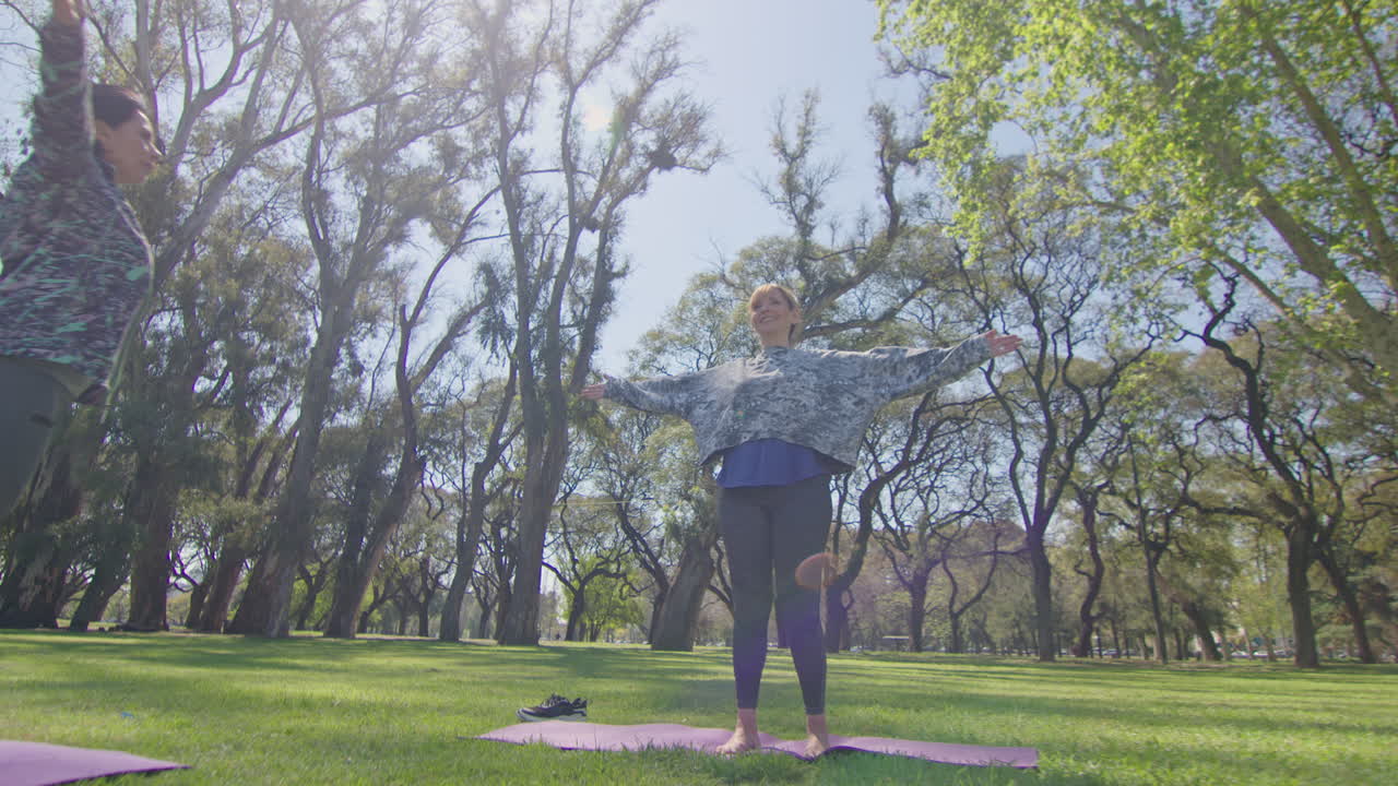 mujeres practicando yoga al aire libre en un parque