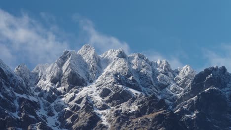 Timelapse-De-Escarpadas-Montañas-Nevadas-Con-Hermosas-Nubes-Rodando-Con-Un-Cielo-Azul