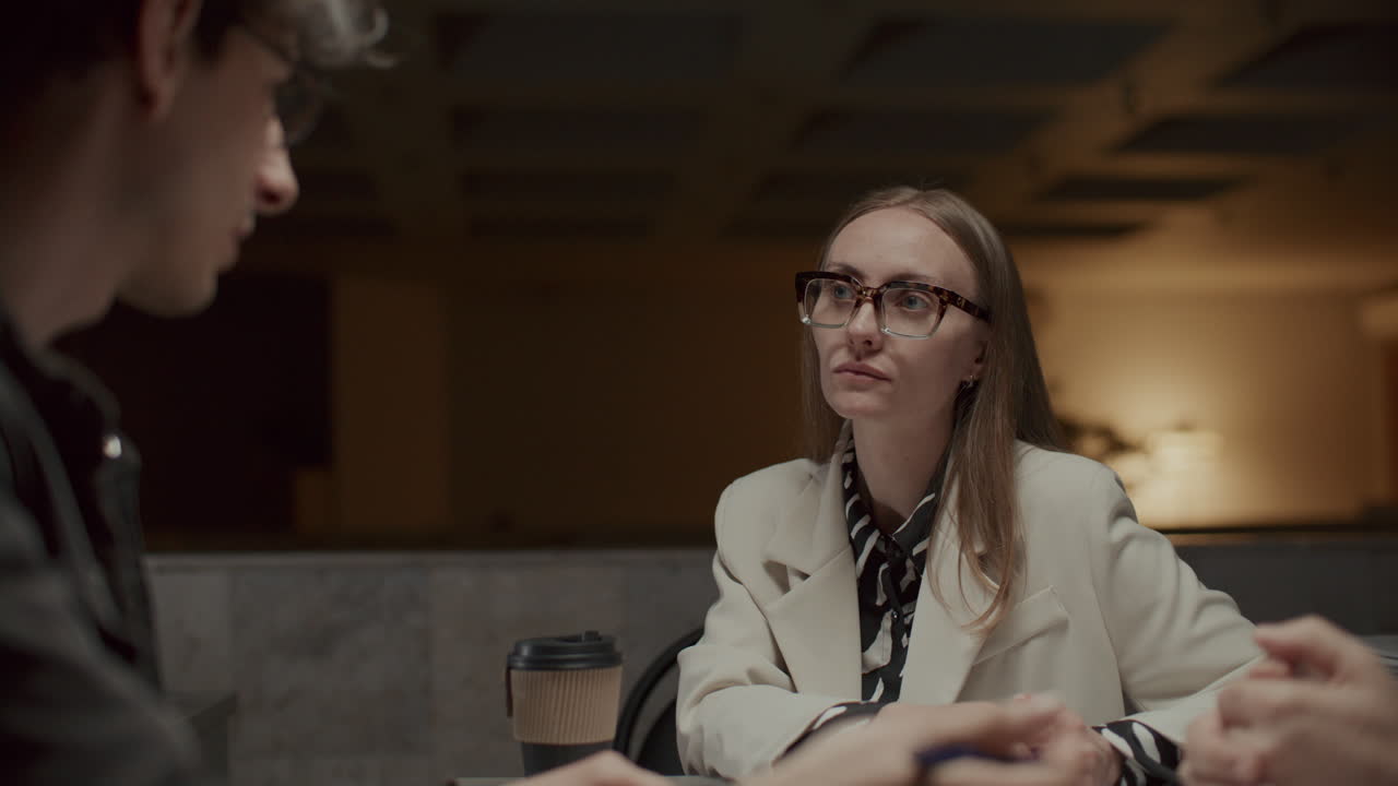 Man Discussing Project with Female Manager at Late Night Office Meeting