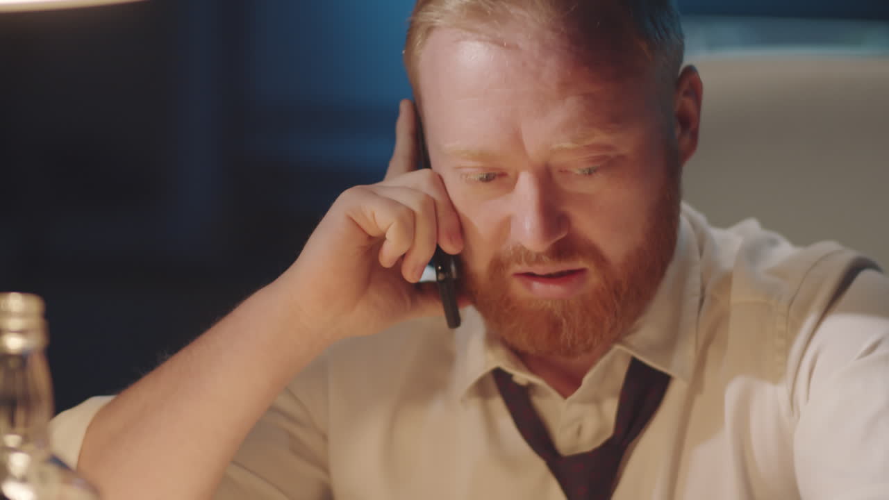Businessman talking on phone at night in office