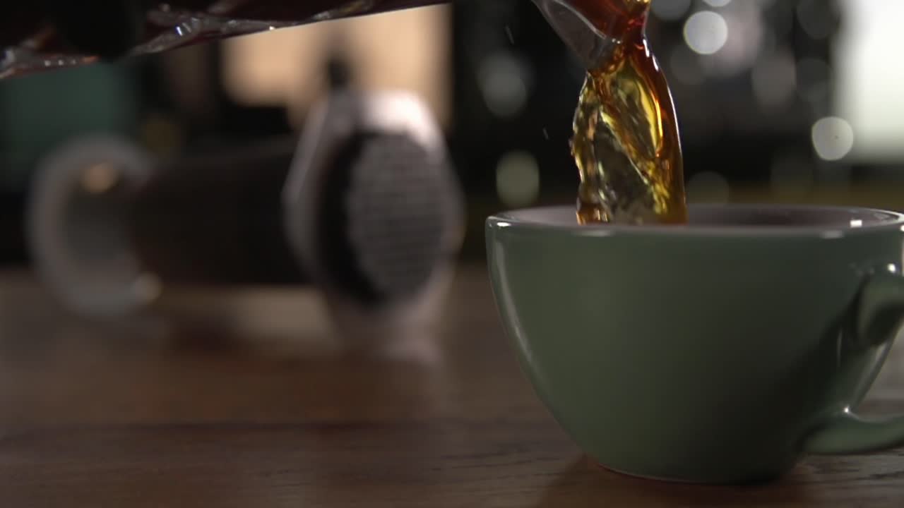 차 는 나무 의 테이블 위 에 있는 민트 녹색 차 컵 의 꼭대기 에  ⁇ 는다