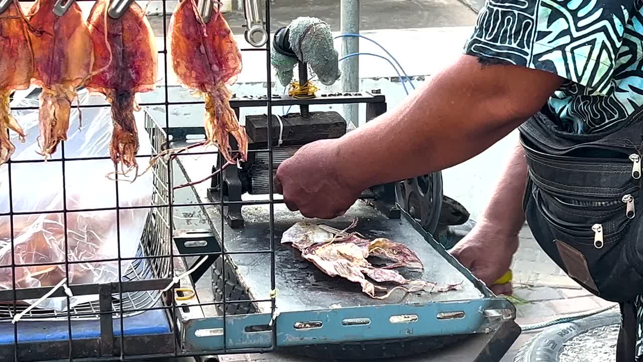 venditore che prepara calamari secchi per la vendita