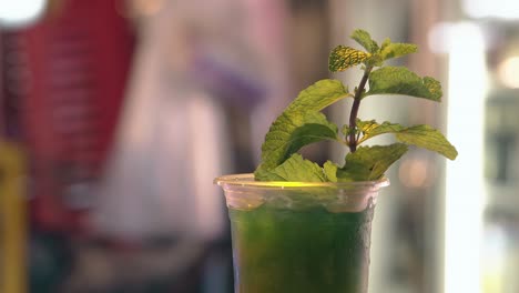 mint cocktail on blurred background with bright lights