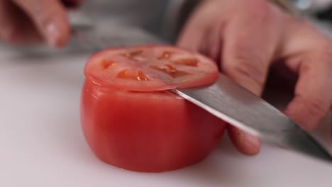 chef cutting a tomato