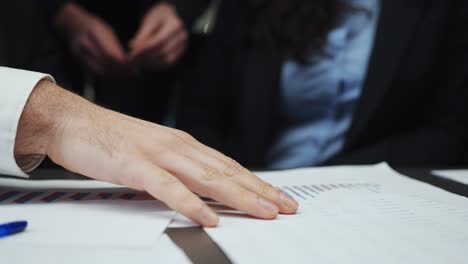 hands of business people working with papers and checking graphics