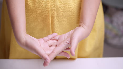 stetching her hands and fingers, the woman is trying to relieve herself of the some inflammation and pain that she is feeling