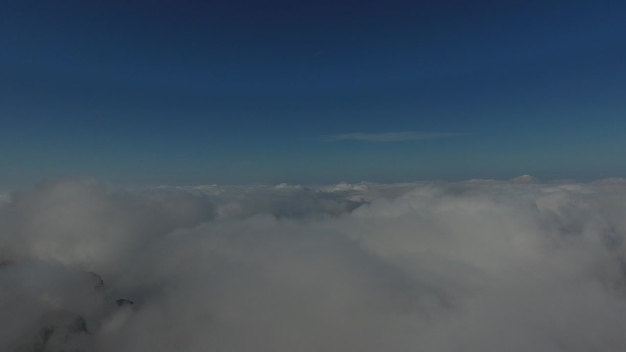 volando sobre las altas montañas en hermosas nubes. vista aérea.