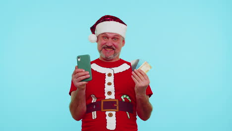 Man-in-Christmas-red-t-shirt-use-mobile-cell-phone,-plastic-credit-bank-cards,-win,-calebrate,-wow