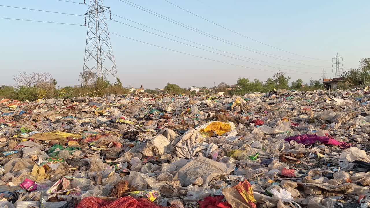 wide angle tracking shot of a dumping yard filled with plastic and other garbage