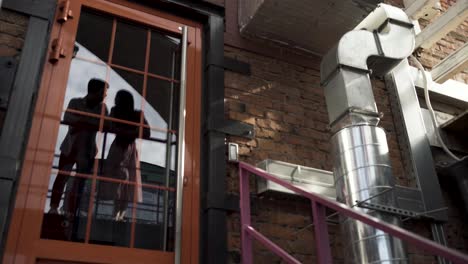 couple reflected in a building door