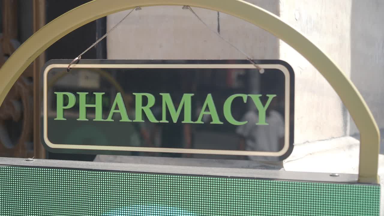 상점 앞에 매달린 약국 표지판.