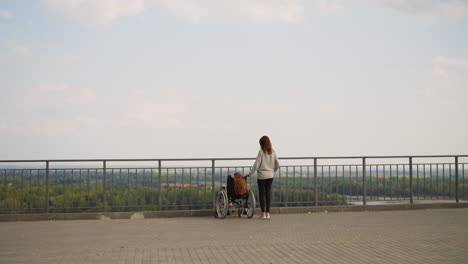 mother shows river and park to daughter with cerebral palsy