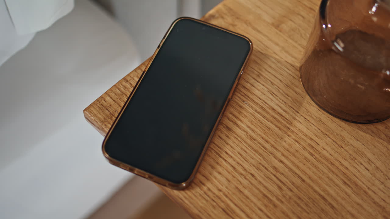 Closeup smartphone wooden table in ambient bedroom setting. Locked ...