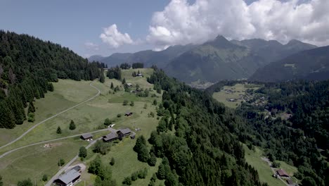 French-Alps-mountain-slope-meadows-and-valley-above-village-Les-Gets-during-summer-with-high-mountaintops-in-the-background-surrounded-by-clouds