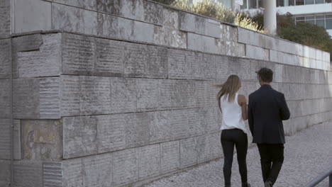 Back view of couple walking together on street