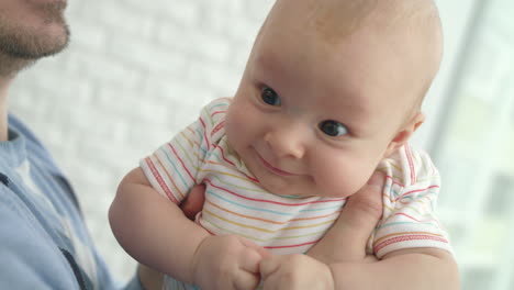 Entzückendes-Baby-In-Männlichen-Händen.-Nahaufnahme-Des-Vaters,-Der-Seinen-Sohn-In-Der-Hand-Hält