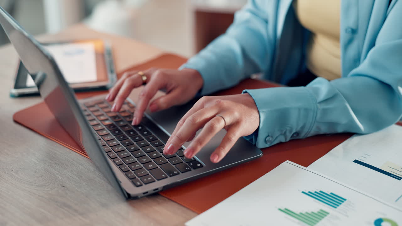 Woman typing on a laptop at her desk