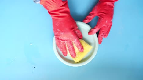 cleaning a dish with gloves and sponge