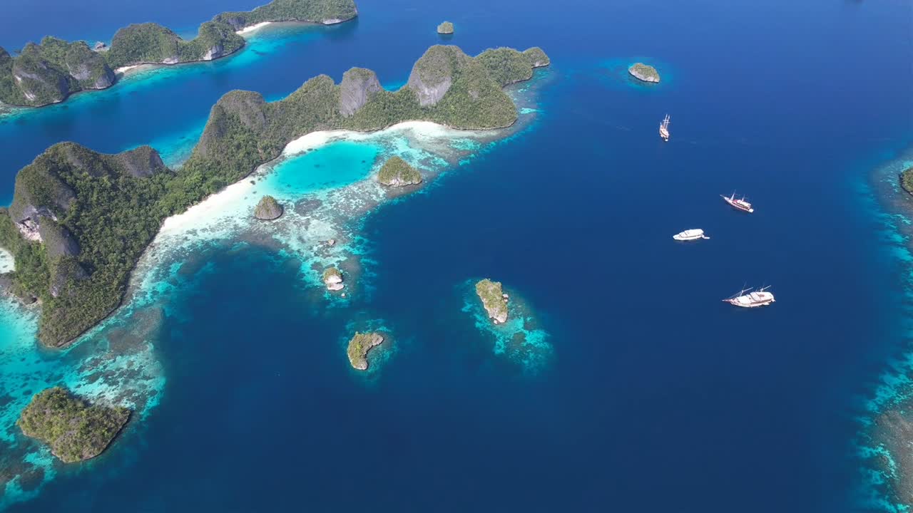 Incredible view on islands formations with white sandy beaches, lagoons, coral reefs and anchored ships in Raja Ampat, Wayag, Indonesia