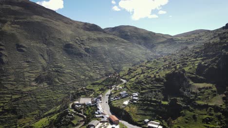 Following-shot-of-a-car-going-through-the-green-mountains-in-a-valley-in-Peru