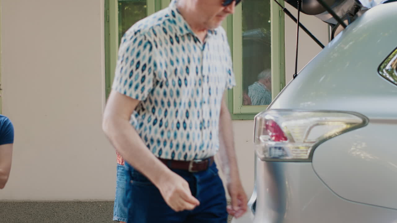 People packing luggage in car