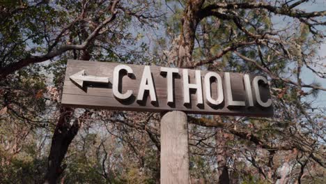 wooden cemetery sign pointing to catholic section of graveyard - 4k