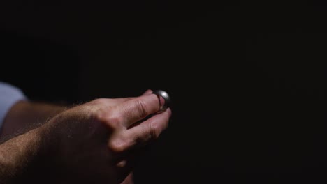 Close-Up-Of-Depressed-Divorced-Mature-Man-Sitting-In-Darkness-Holding-Wedding-Ring-With-Low-Key-Lighting-1