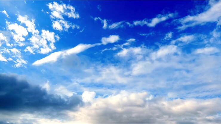 Timelapse di nuvole che si muovono in un cielo azzurro brillante, mostrando il movimento atmosferico naturale e il cambiamento del tempo in una tranquilla scena all'aperto.
