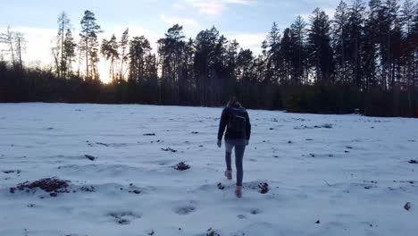 A-Girl's-Stroll-Through-a-Snowy-Clearing-at-Sunset