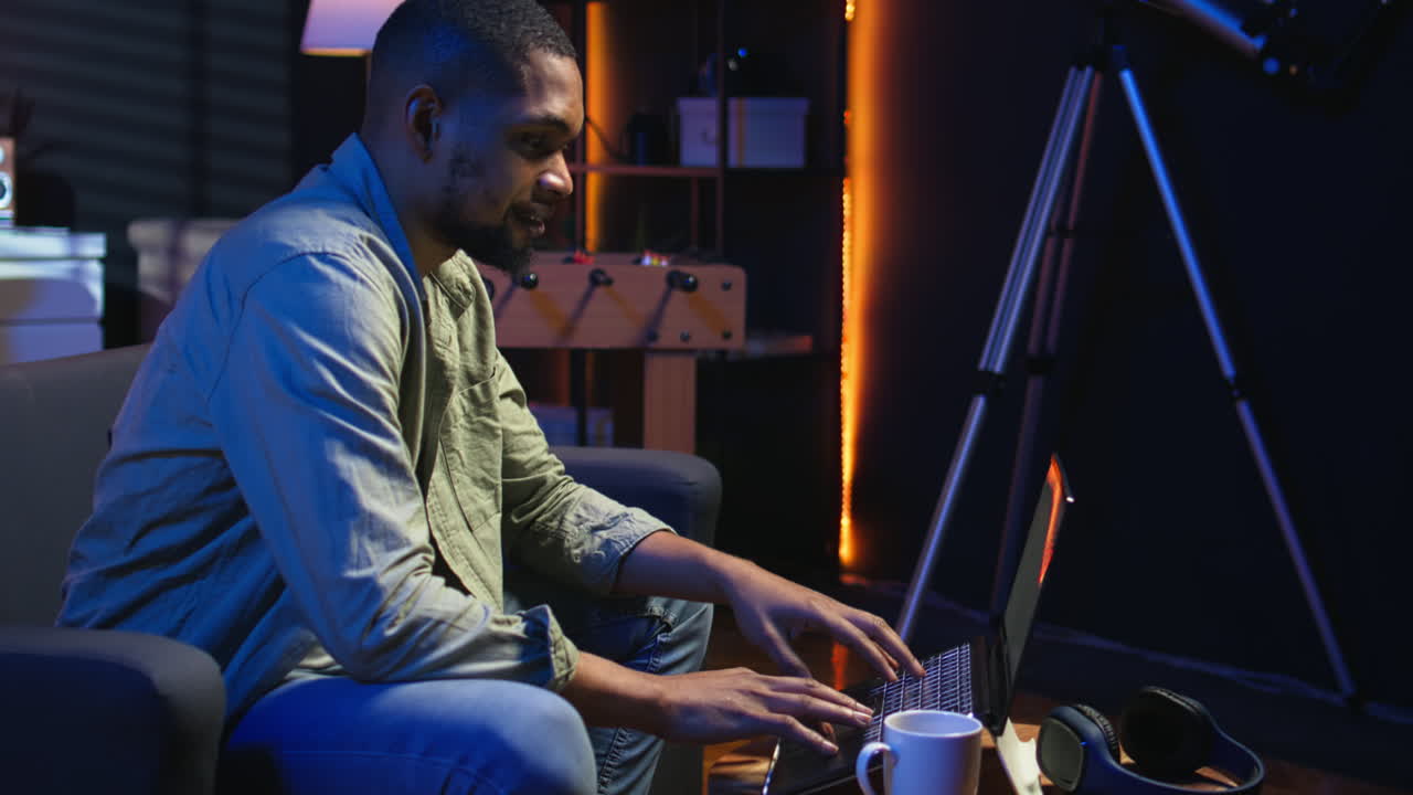 Vertical Video Young black adult working on his freelance tasks in the living room
