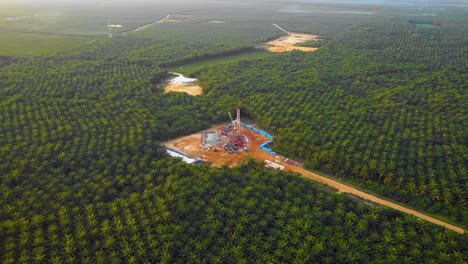 cinematic 4k drone footage of onshore drilling rig equipment structure for oil exploration and exploitation in the middle of jungle surrounded by palm oil trees during sunset and high oil price