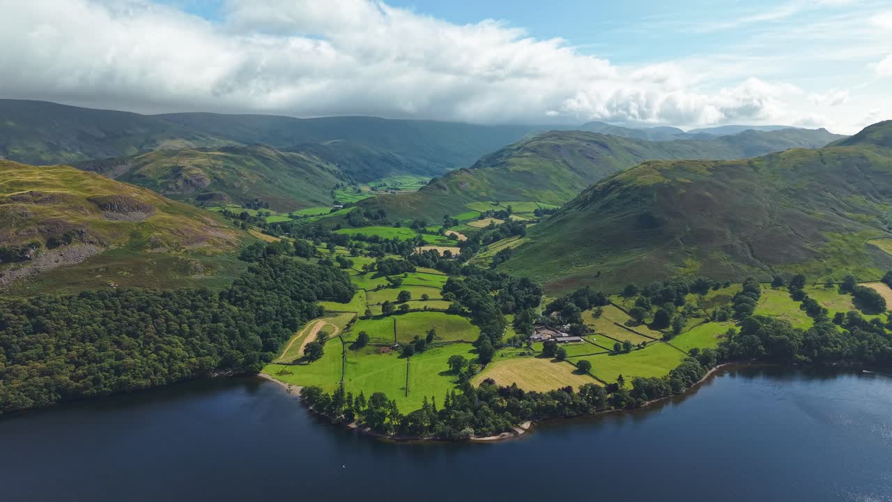 Picturesque green valley with fells and fields beside Ullswater in the Lake District
