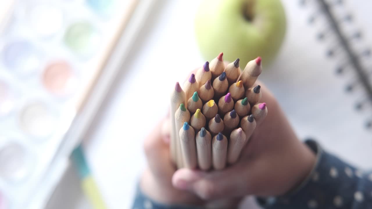 색의 연필 한 어리를 들고 있는 아이