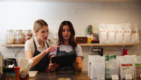 baristas working with a tablet in a coffee shop