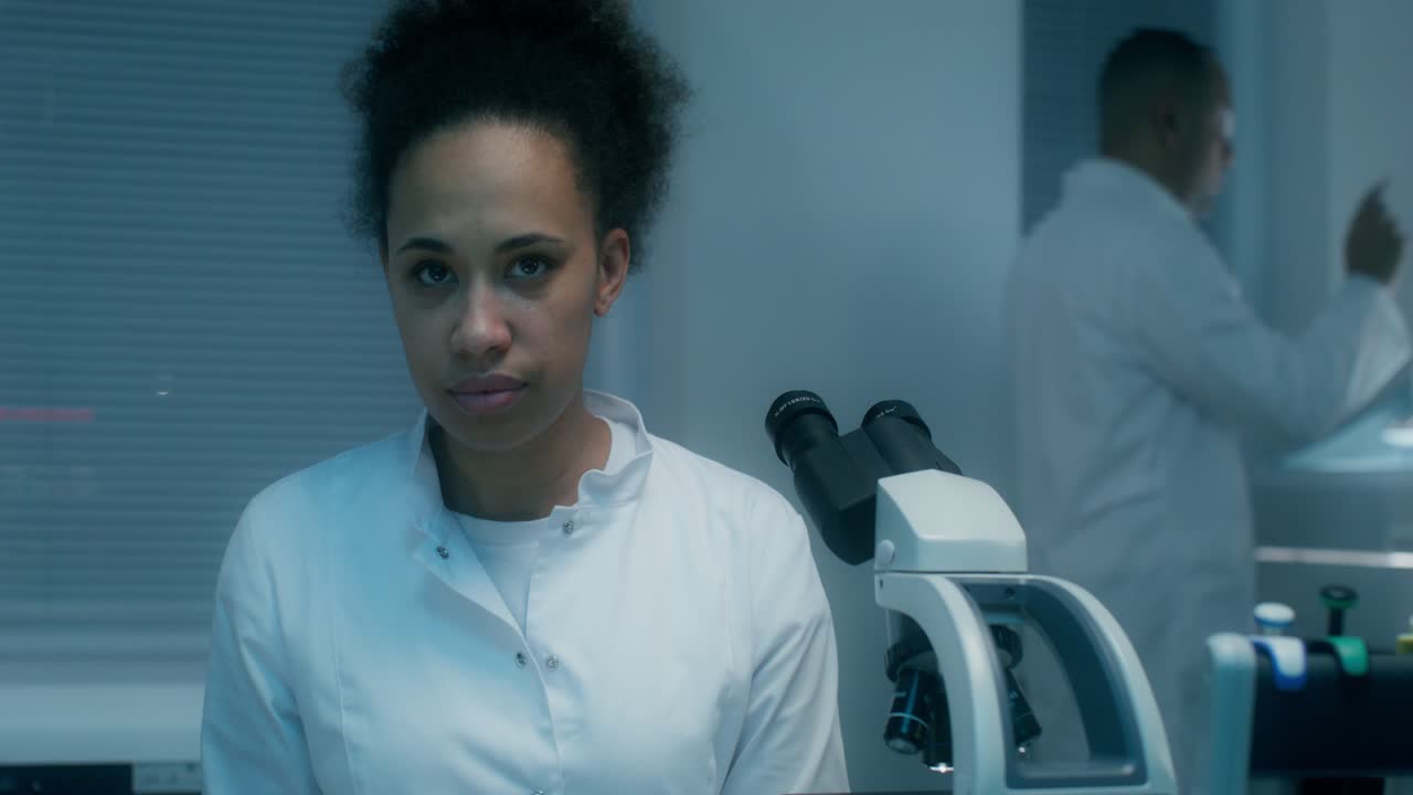 Scientist Looking Through Microscope in Laboratory