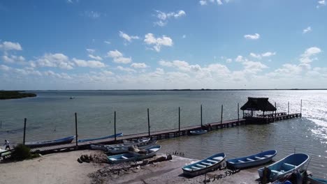 wooden dock and fishing boat at lake blue sky and chelem yucatan mexico