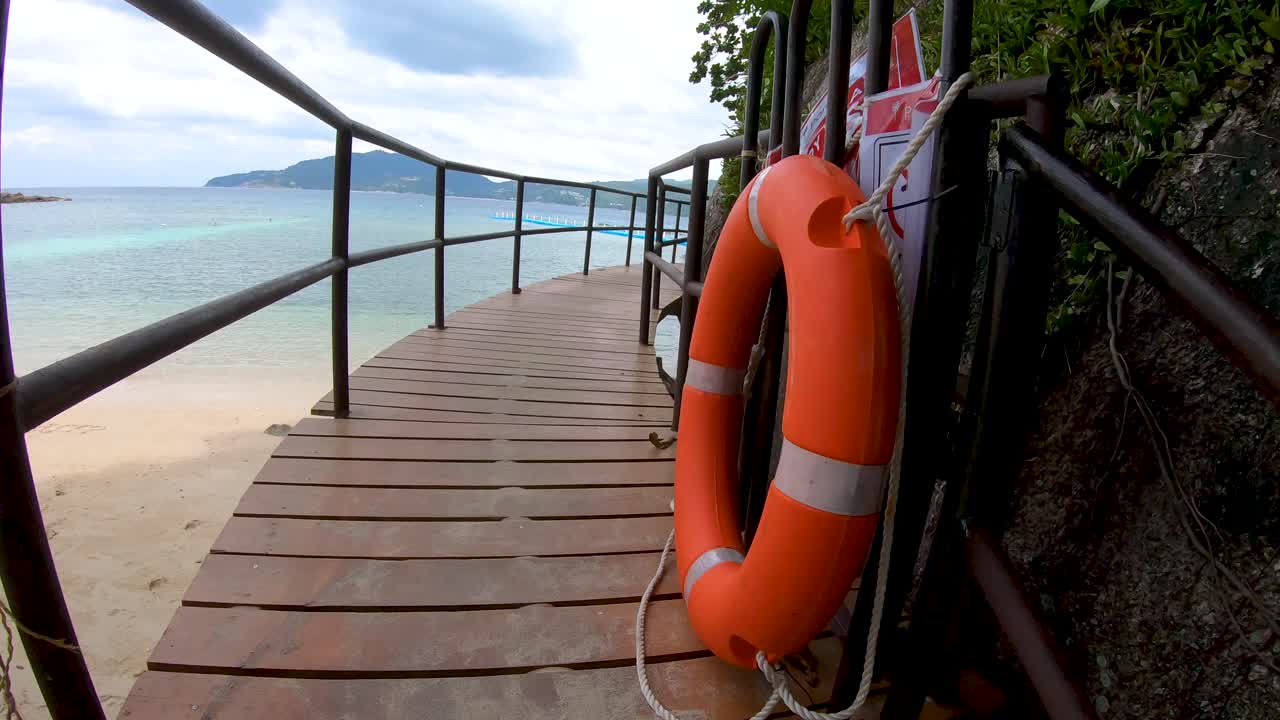 Wooden walkway ramp on the shore of Andaman Sea. Famous tourist attraction. Tropical Beach. Perfect summer getaway.