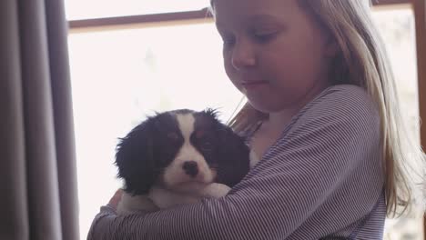 fotografía de cerca de una niña abrazando a su adorable cachorro mientras está envuelta con una toalla