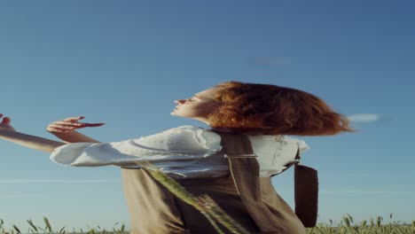 woman enjoying a sunny day in a wheat field