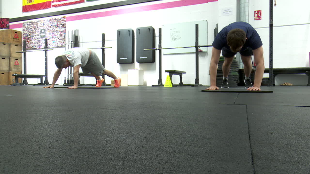 Men doing push-ups and planks in a gym