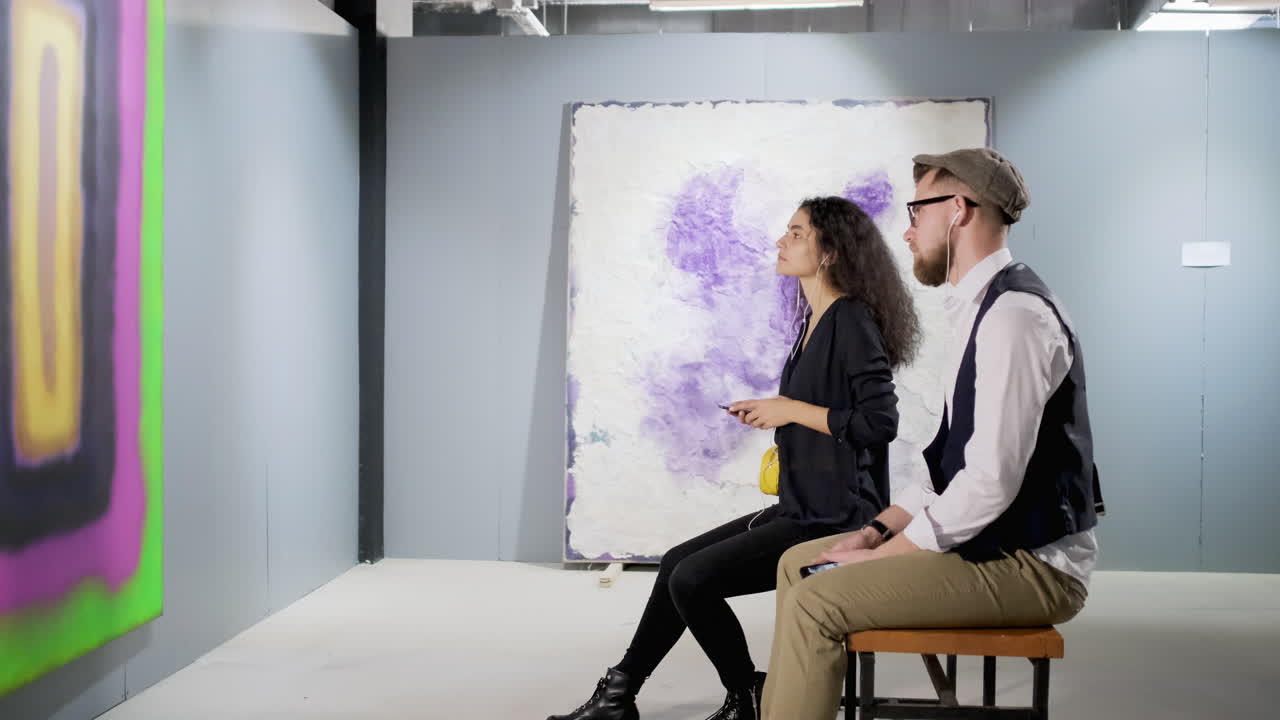 pareja viendo arte abstracto en una galería de arte