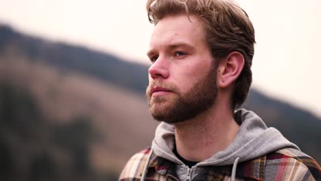 here a man is filmed walking between hills and stroking his hair as he walks