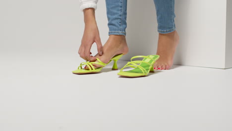 close up of female social media influencer producing user generated content putting on beautiful pair of green shoes 3